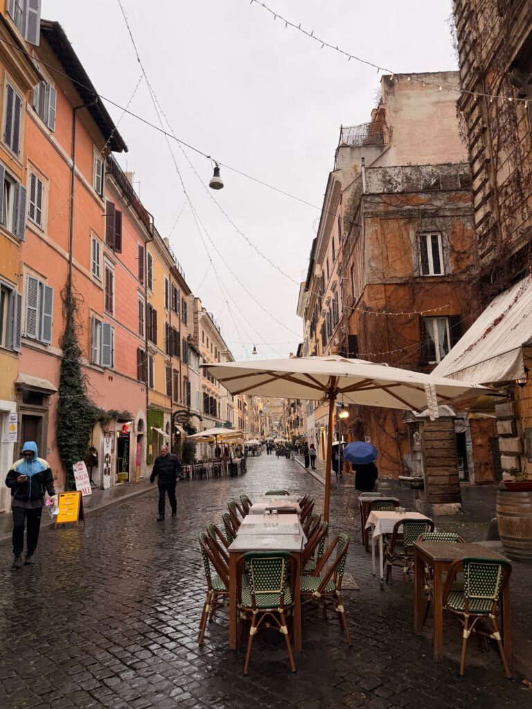 Vegan hotels in Rome - cafe tables on a cobbled street after rain